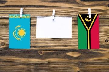 Hanging flags of Kazakhstan and Vanuatu attached to rope with clothes pins with copy space on white...
