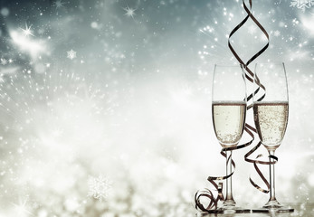 two champagne glasses with ribbons against holiday lights and fireworks - New Year celebrations