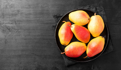 Fresh ripe organic pears on a black wooden table