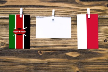 Hanging flags of Kenya and Monaco attached to rope with clothes pins with copy space on white note...