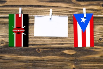 Hanging flags of Kenya and Puerto Rico attached to rope with clothes pins with copy space on white...