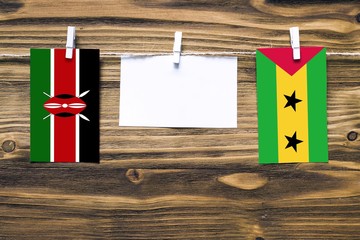 Hanging flags of Kenya and Sao Tome And Principe attached to rope with clothes pins with copy space...