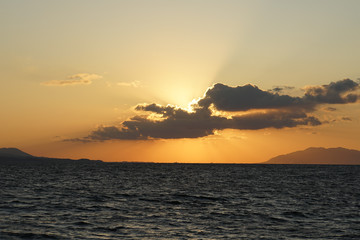 雲に隠れた夕日とまばゆい光線