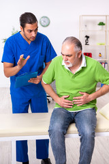Fototapeta premium Old man visiting young male doctor gastroenterologist