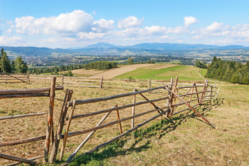 Fototapeta na wymiar Wooden fence on a highlander's pasture in Carpathian Mountains.