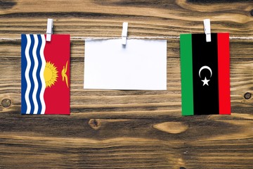Hanging flags of Kiribati and Libya attached to rope with clothes pins with copy space on white...
