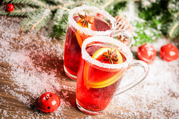 Two glasses of warming traditional mulled wine close-up. Winter homemade drink with spices and orange.