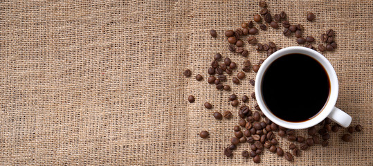 cup of coffee and coffee beans on jute