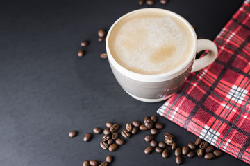 Cup of coffee and coffee beans on a Black Table