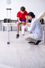 Leg injured boy visiting young doctor traumatologist