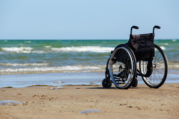 Fototapeta premium Wheelchair stands on the seashore