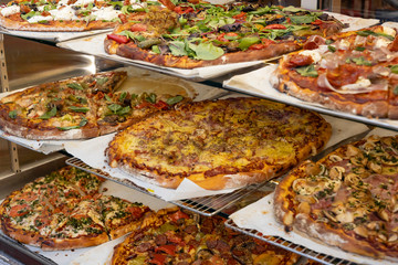 .Assortment of delicious italian pizzas in a shop.