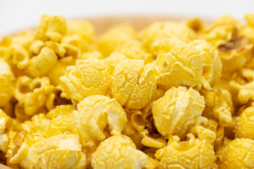 Butter caramel popcorn in wooden bowl bulk on white background, Popular snack with favorite movie