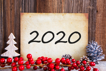 Paper With Text 2020 For Happy New Year Greetings. Christmas Decoration And Wooden Background