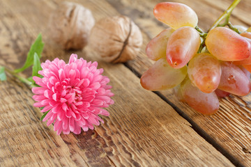 Close-up flower and grapes on the wooden natural background