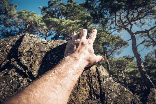 Development Attainment Motivation Career Growth Concept. Man's hand clings to a rock. Concept of motivation, success, willpower