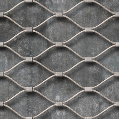 Seamless texture of hand woven mesh fence made of stainless wire and concrete wall as a background....