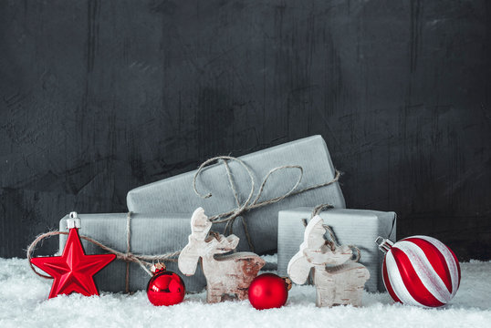 Green Christmas Present With Red Decoration Like Reindee and Ball. Black Background With Copy Space