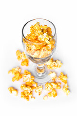 The popcorn is in a wine glass and placed on the floor, isolated white background