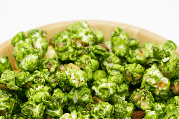 Lush of Japanese matcha green tea popcorn in the wooden bowl bulk isolated on white background, Popular snack with favorite movie