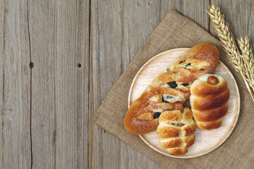 Sausage bread and wheat ears and sack on wooden background,top view