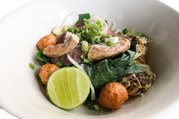 Noodles with boiled pork Consisting of pork offal ,Meatballs and bean sprouts sprinkled with sliced onions and lemon slide