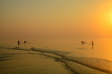 Tropical sunrise seascape with ocean net fishermen at Huay Yang beach resort, Thailand.