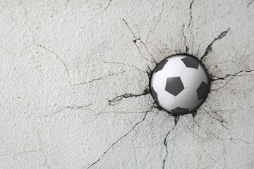 Sport soccer ball coming in cracked wall with grunge texture.