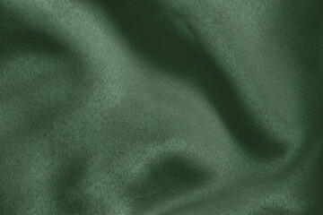 Dark green colored Background of soft draped fabric. Beautiful satin silk textured cloth for making clothes and curtains. Elegant textile texture.