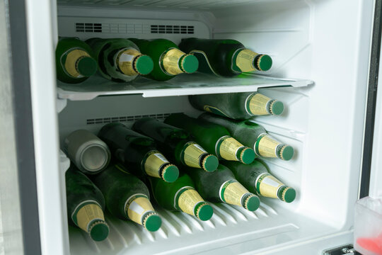 Bottles full of beer in a refrigerator.