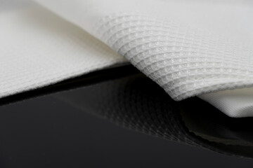 Macro shot texture of folded white towel kitchen fabric isolated on black background