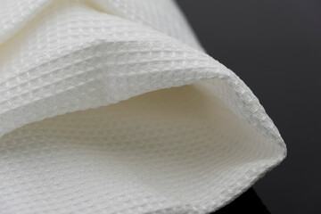 Macro shot texture of folded white towel kitchen fabric isolated on black background