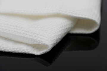 Fototapeta na wymiar Macro shot texture of folded white towel kitchen fabric isolated on black background