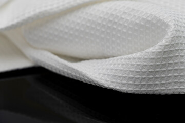 Macro shot texture of folded white towel kitchen fabric isolated on black background