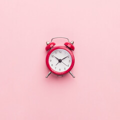 Red toy alarm clock on pink background