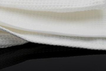 Macro shot texture of folded white towel kitchen fabric isolated on black background