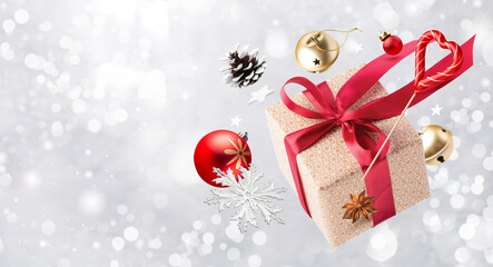 Happy New year magic concept. Christmas gifts, Lollipop, decorations and toys are fly or fall in the air on a grey shine background.