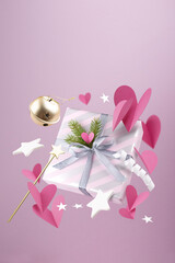Happy New year magic concept. Christmas gifts, fairy wand, hearts, decorations and toys are fly or fall in the air on a pink background.