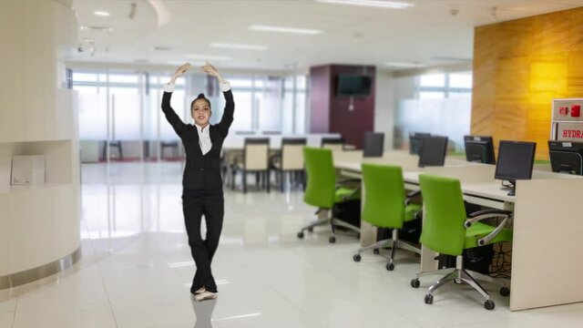 Slow motion of happy businesswoman with ballet skill expressing her success by jumping in the office room