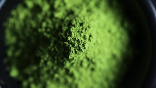 Powdered hill green tea in the bowl at dark background