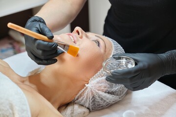 Close up of beautiful mature woman lying on procedure in spa salon