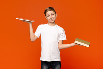 Teenager comparing digital tablet and printed book