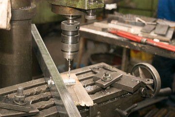 drill bit drills a hole in the metal part