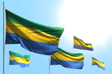 pretty anthem day flag 3d illustration. - 5 flags of Gabon are wave against blue sky picture with soft focus