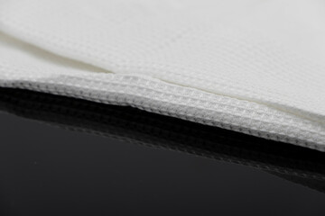 Macro shot texture of folded white towel kitchen fabric isolated on black background