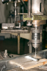 drill bit drills a hole in the metal part