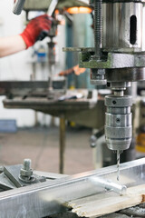 drill bit drills a hole in the metal part