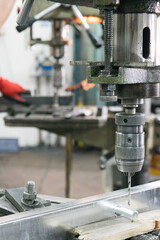 drill bit drills a hole in the metal part