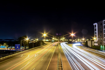 Fototapeta na wymiar Traffic lights on city road during night in Perth, WA Australia