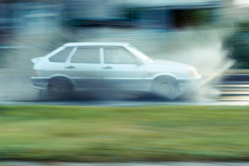 Fototapeta na wymiar Car in motion puddle of spray